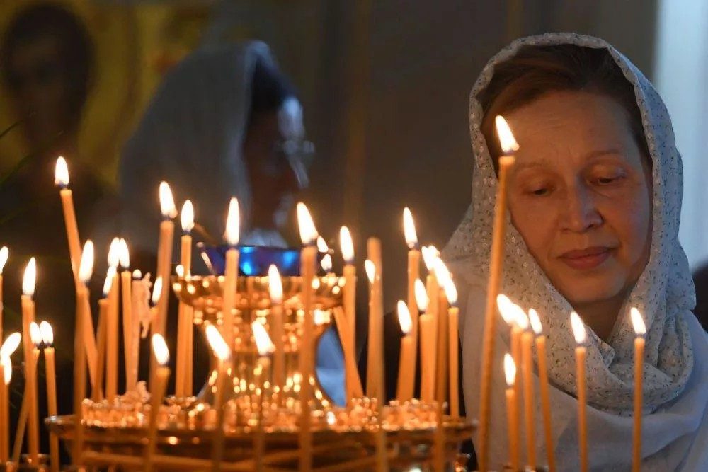 Женщина в церкви со свечами