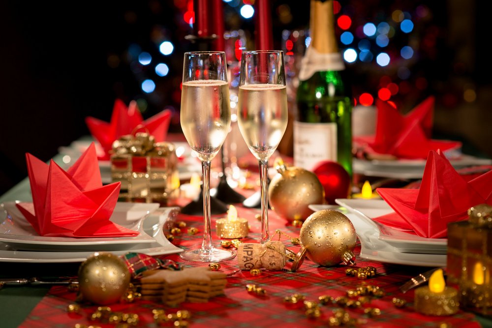 Бокалы и бутылка шампанского, новогодние шары, тарелки с салфетками
