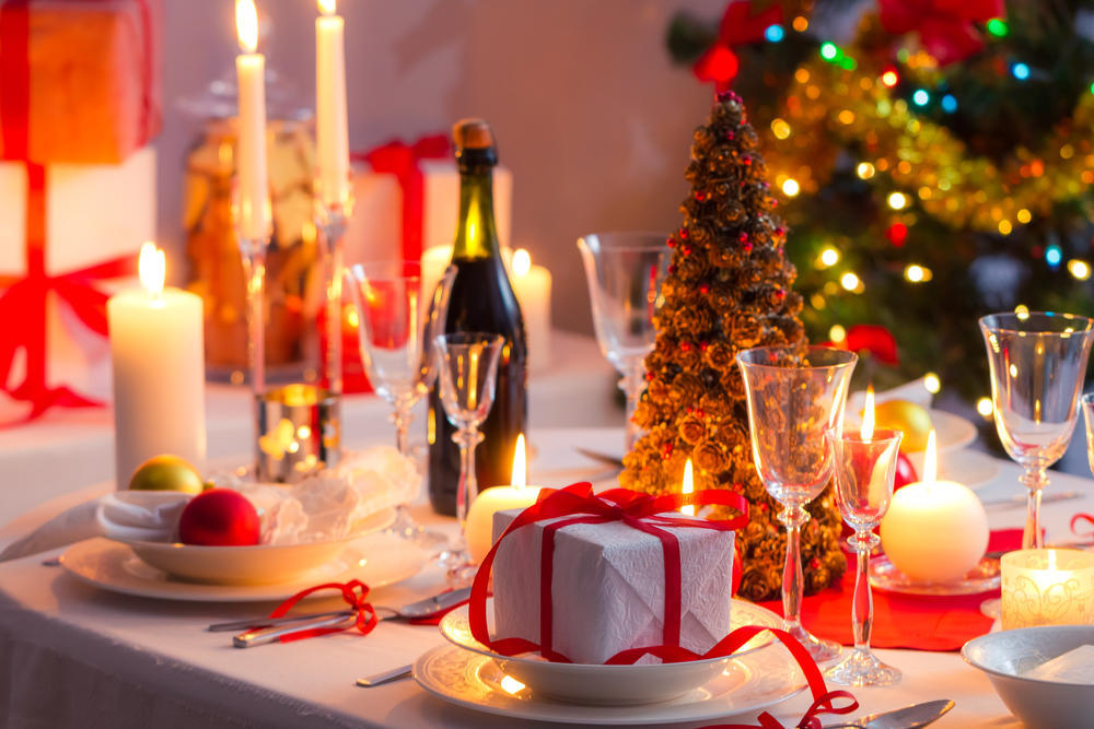 Наряженная елка, бутылка шампанского, тарелки, подарок, свечи, бокалы