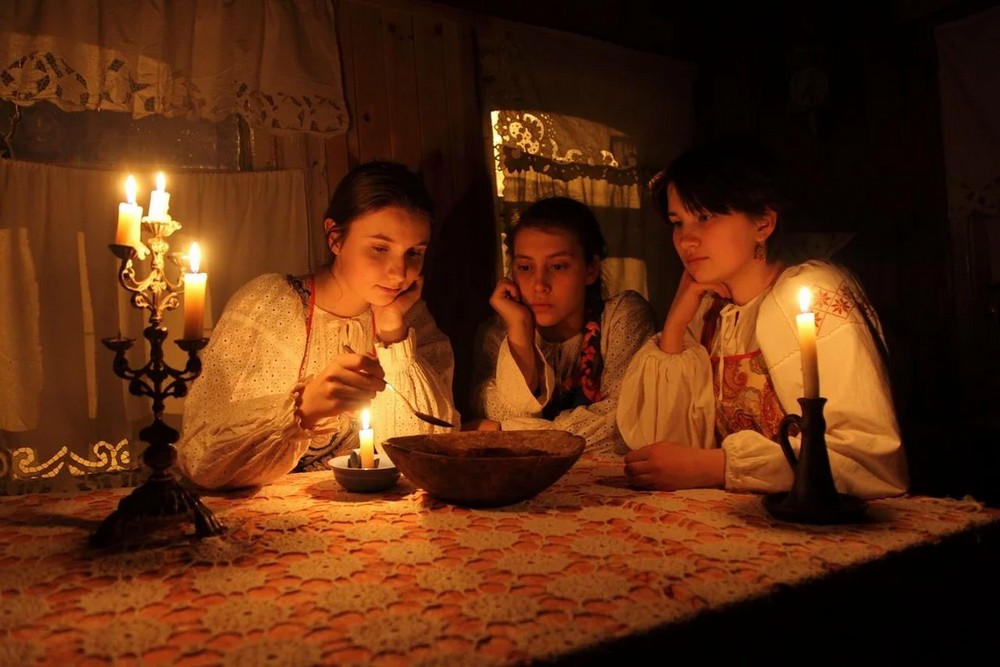 Девушки, свечи в подсвечнике, миска на столе, окно