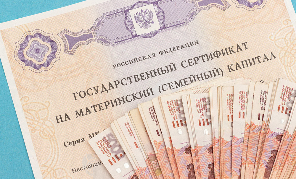 Сертификат на материнский капитал и денежные купюры