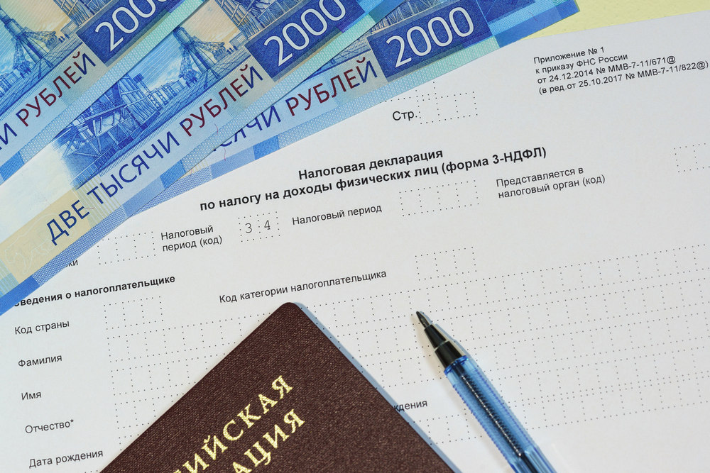 Деньги и паспорт возле налоговой декларации