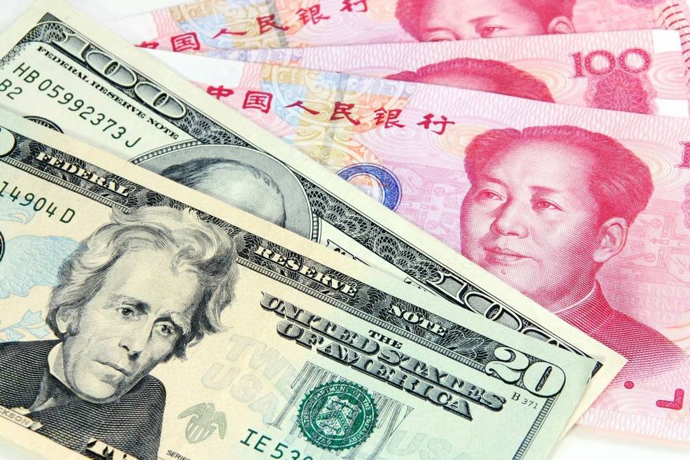 Долларовые денежные купюры и юань