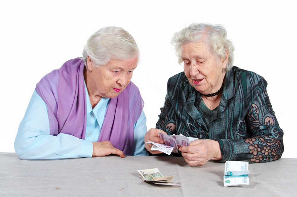 Пенсионеры с деньгами за столом