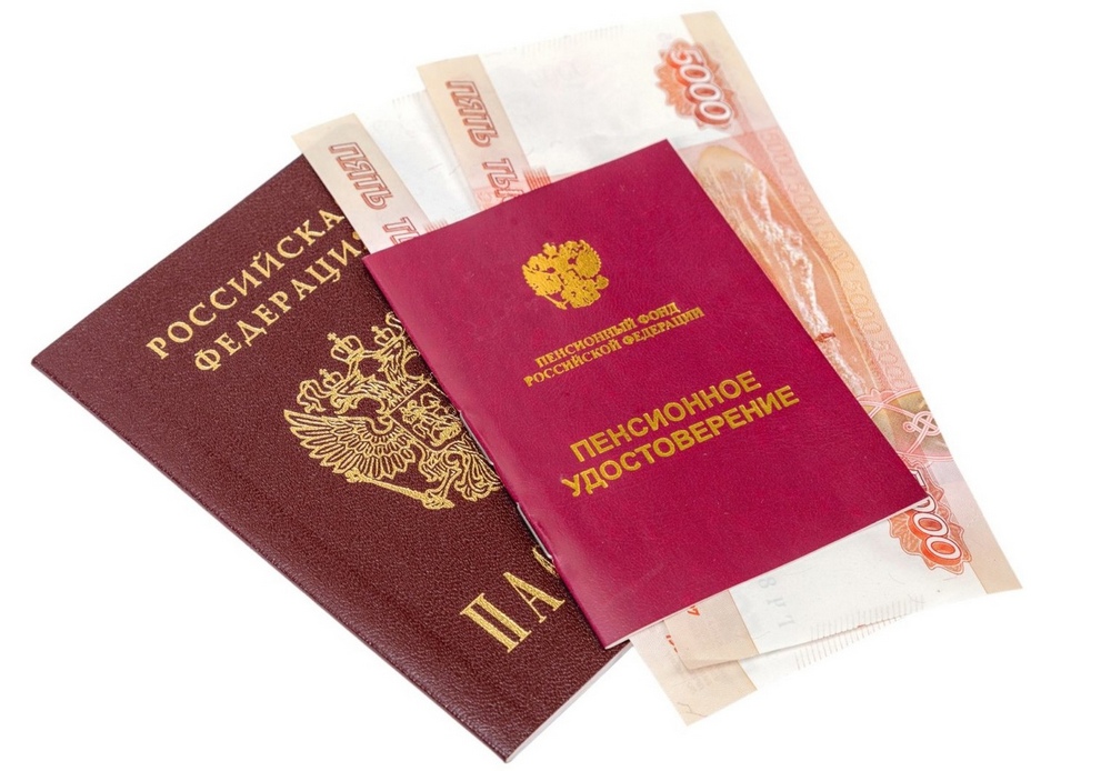 Денежные купюры в пенсионном удостоверении возле паспорта